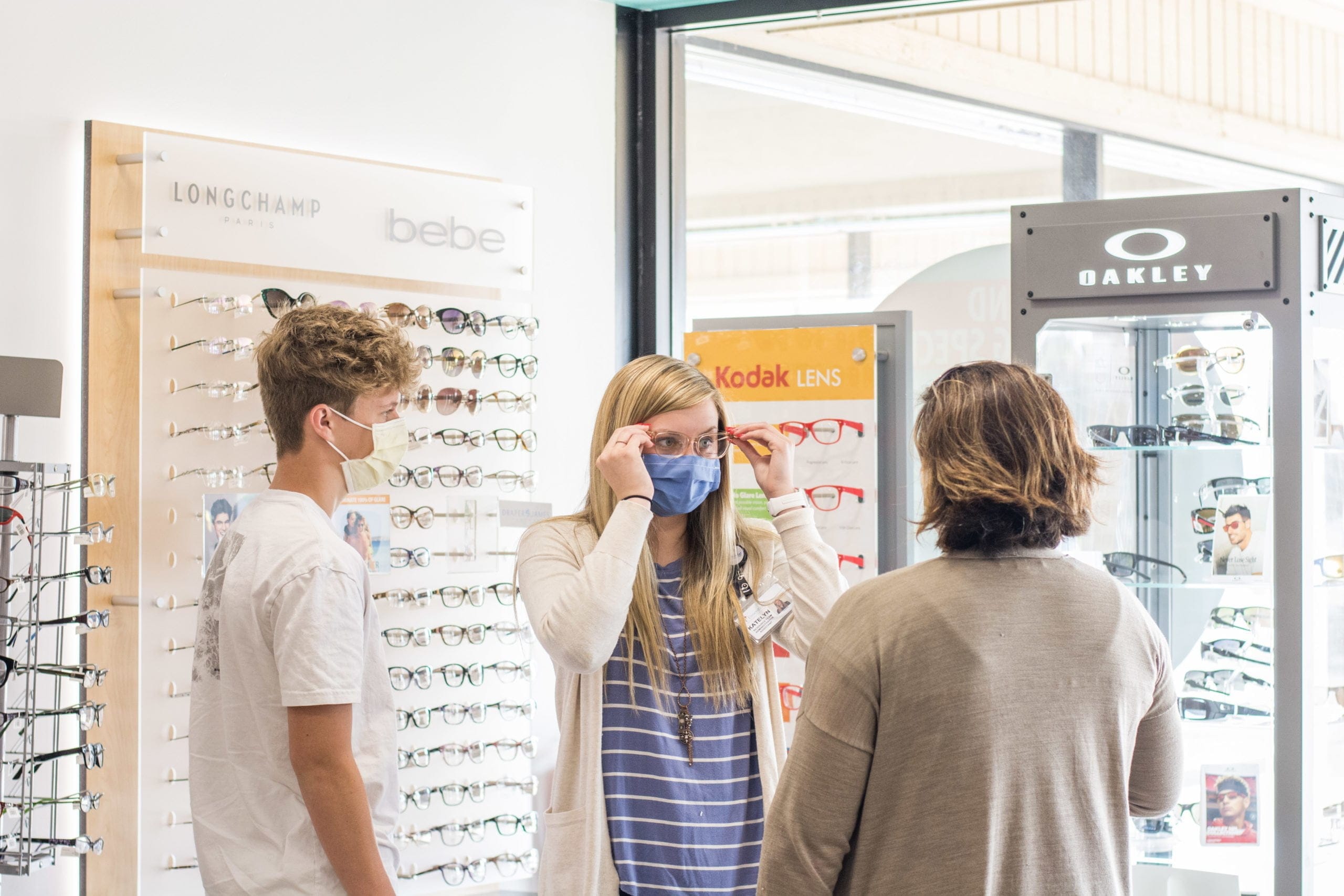 family trying on glasses while wearing masks