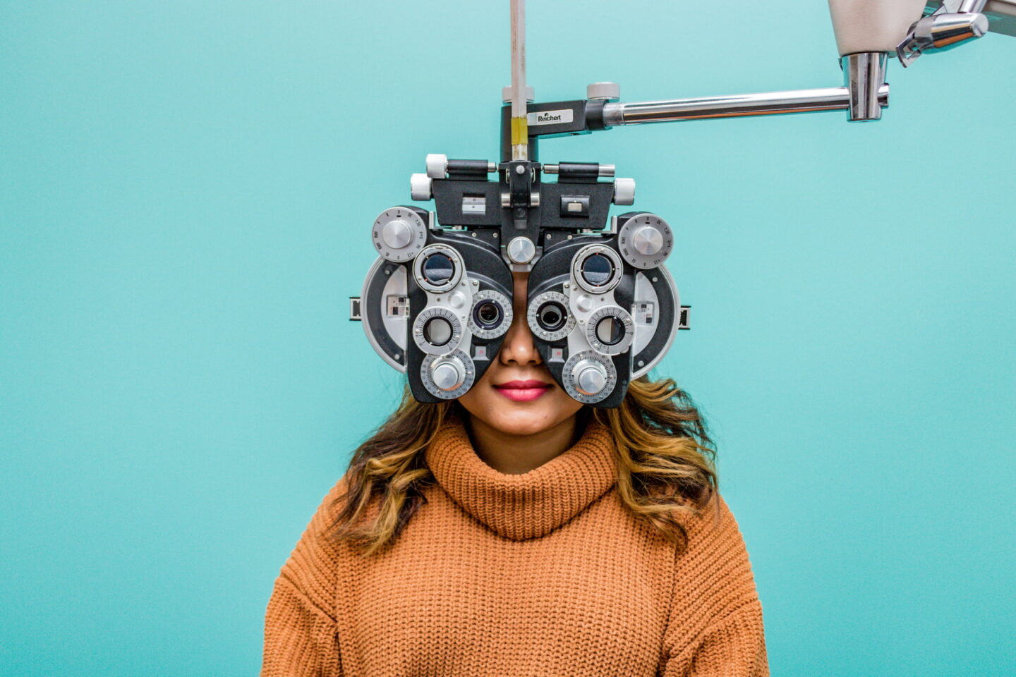 patient sitting behind phoropter during in-office eye exam with a virtual eye doctor