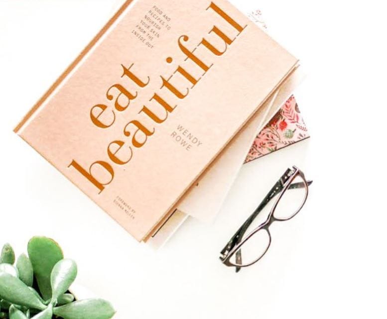 glasses sitting on white table with a box that reads, eat beautiful