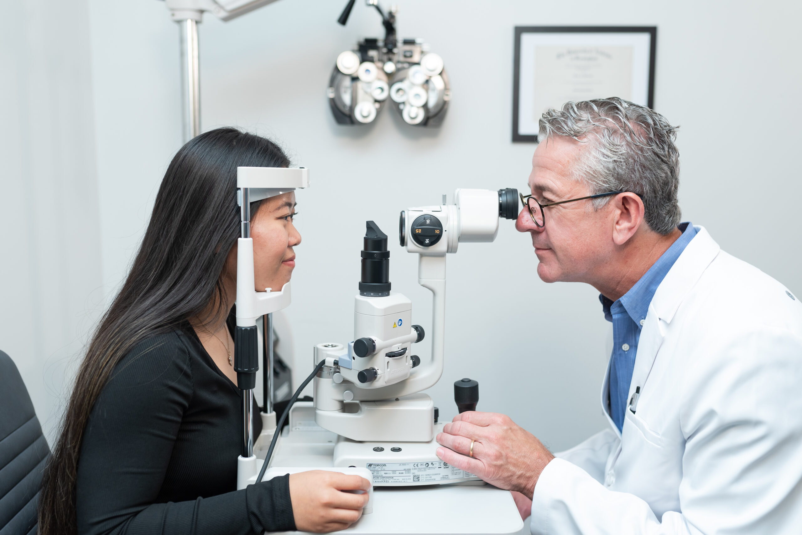 doctor look at patient's eye with a slit lamp during an eye exam